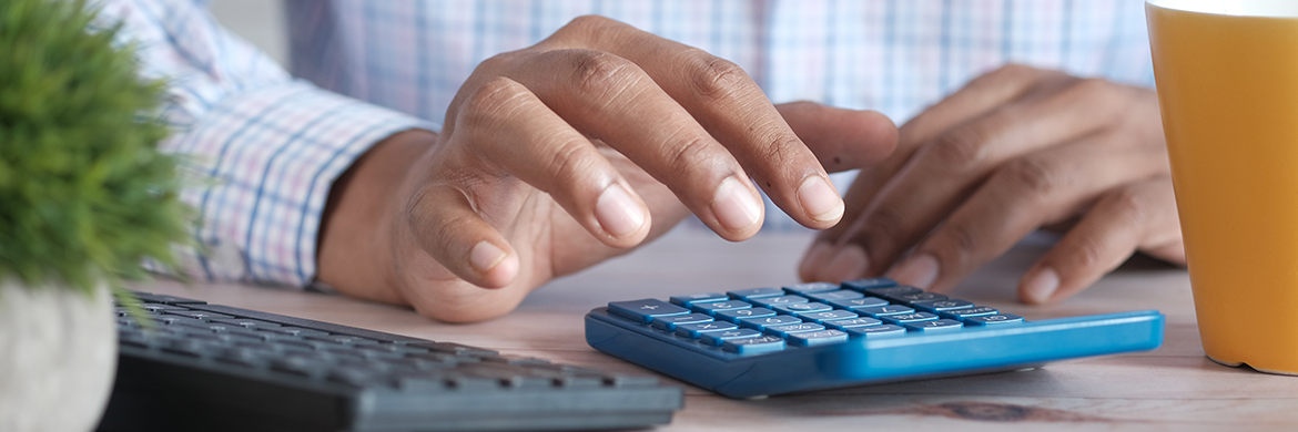 Tax Info header image showing a man with a laptop and calculator on his desk