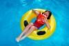 Photo of a child reading while floating on a pool tube