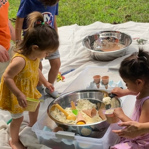 Children playing outside with sensory materials 