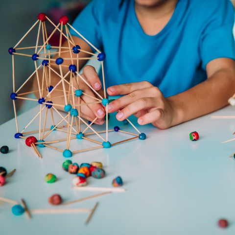 Image of a child building using toothpicks and playdough