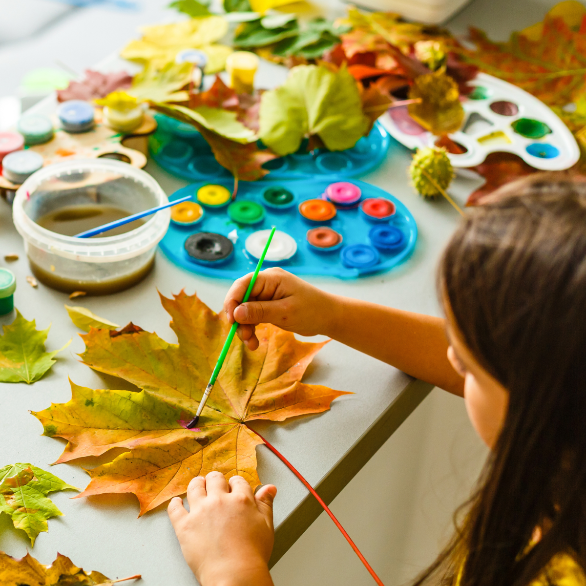 Child painting a leaf