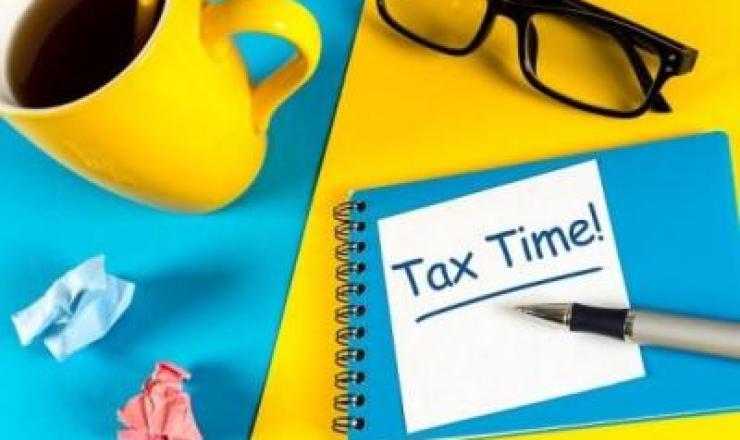 Image of a notebook with Tax Time! on it with yellow and blue details